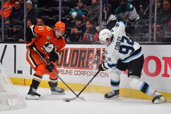 Nov 17, 2025; Anaheim, California, USA; Anaheim Ducks left wing Cutter Gauthier (61) and Utah Mammoth center Logan Cooley (92) play for the puck during the third period at Honda Center. Mandatory Credit: Gary A. Vasquez-Imagn Images