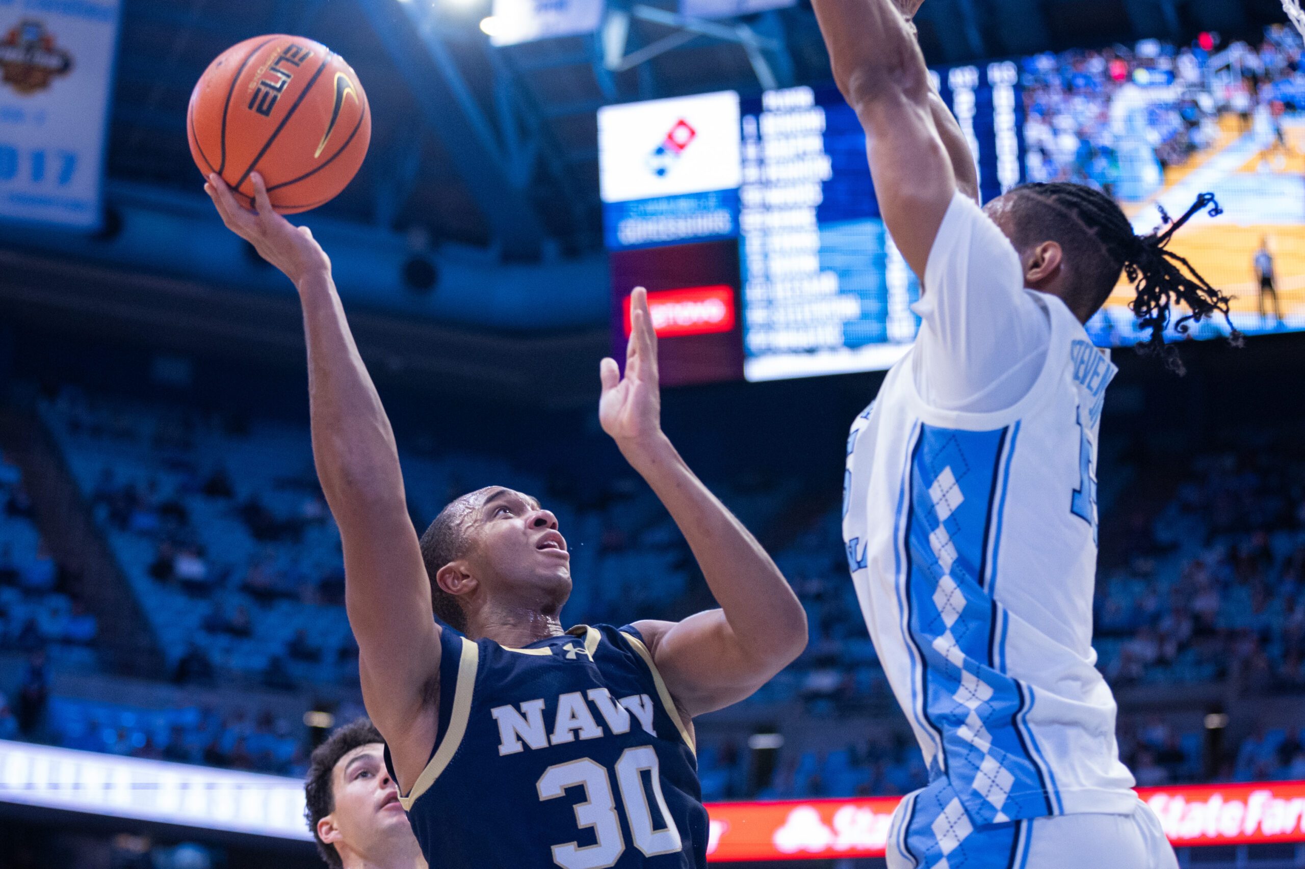 Nov 18, 2025; Chapel Hill, North Carolina, USA; Navy Midshipmen forward Mike Woods (30) shoots on North Carolina Tar Heels forward Jarin Stevenson (15) during the first half at Dean E. Smith Center. Mandatory Credit: Scott Kinser-Imagn Images