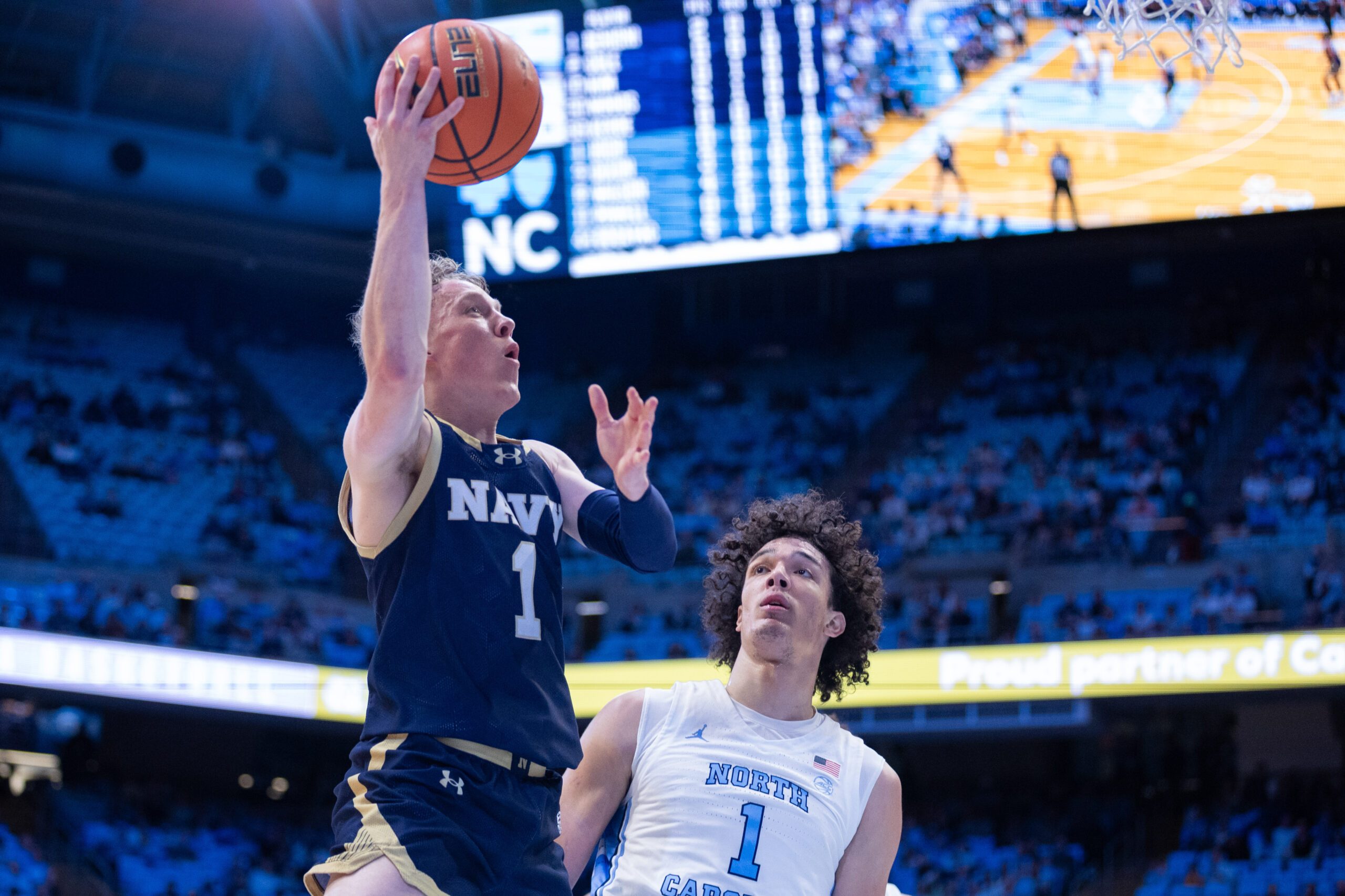 Nov 18, 2025; Chapel Hill, North Carolina, USA; Navy Midshipmen guard Austin Benigni (1) shoots on North Carolina Tar Heels forward Zayden High (1) during the first half at Dean E. Smith Center. Mandatory Credit: Scott Kinser-Imagn Images