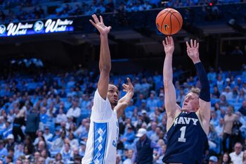 Nov 18, 2025; Chapel Hill, North Carolina, USA; Navy Midshipmen guard Austin Benigni (1) shoots against North Carolina Tar Heels forward Jarin Stevenson (15) during the first half at Dean E. Smith Center. Mandatory Credit: Scott Kinser-Imagn Images
