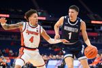 Nov 18, 2025; Syracuse, New York, USA; Monmouth Hawks forward Jason Rivera-Torres (1) drives against Syracuse Orange guard Nate Kingz (4) during the first half at the JMA Wireless Dome. Mandatory Credit: Rich Barnes-Imagn Images