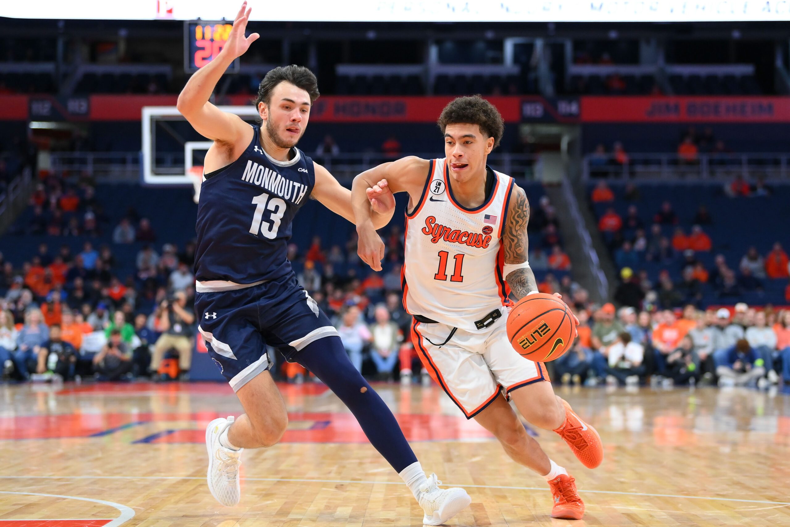 Nov 18, 2025; Syracuse, New York, USA; Syracuse Orange guard Naithan George (11) drives against Monmouth Hawks guard Jack Collins (13) during the second half at the JMA Wireless Dome. Mandatory Credit: Rich Barnes-Imagn Images