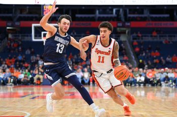 Nov 18, 2025; Syracuse, New York, USA; Syracuse Orange guard Naithan George (11) drives against Monmouth Hawks guard Jack Collins (13) during the second half at the JMA Wireless Dome. Mandatory Credit: Rich Barnes-Imagn Images