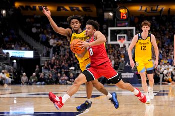 Nov 19, 2025; Milwaukee, Wisconsin, USA;  Dayton Flyers guard Javon Bennett (0) drives for the basket against Marquette Golden Eagles guard Nigel James Jr. (0) during the first half at Fiserv Forum. Mandatory Credit: Jeff Hanisch-Imagn Images