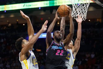 Nov 19, 2025; Miami, Florida, USA;  Miami Heat forward Andrew Wiggins (22) shoots between Golden State Warriors forward Trayce Jackson-Davis (32) and forward Gui Santos (15) during the second half at Kaseya Center. Mandatory Credit: Rhona Wise-Imagn Images