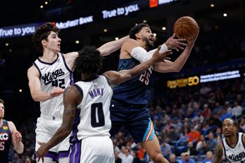 Nov 19, 2025; Oklahoma City, Oklahoma, USA; Oklahoma City Thunder guard Ajay Mitchell (25) goes up for a basket between Sacramento Kings center Maxime Raynaud (42) and guard Malik Monk (0) during the second half at Paycom Center. Mandatory Credit: Alonzo Adams-Imagn Images