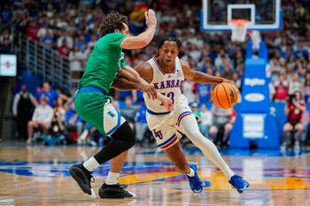 Nov 11, 2025; Lawrence, Kansas, USA; Kansas Jayhawks guard Elmarko Jackson (13) drives against Texas A&M-Corpus Christi Islanders forward Jaden Haire (11) during the first half at Allen Fieldhouse. Mandatory Credit: Jay Biggerstaff-Imagn Images