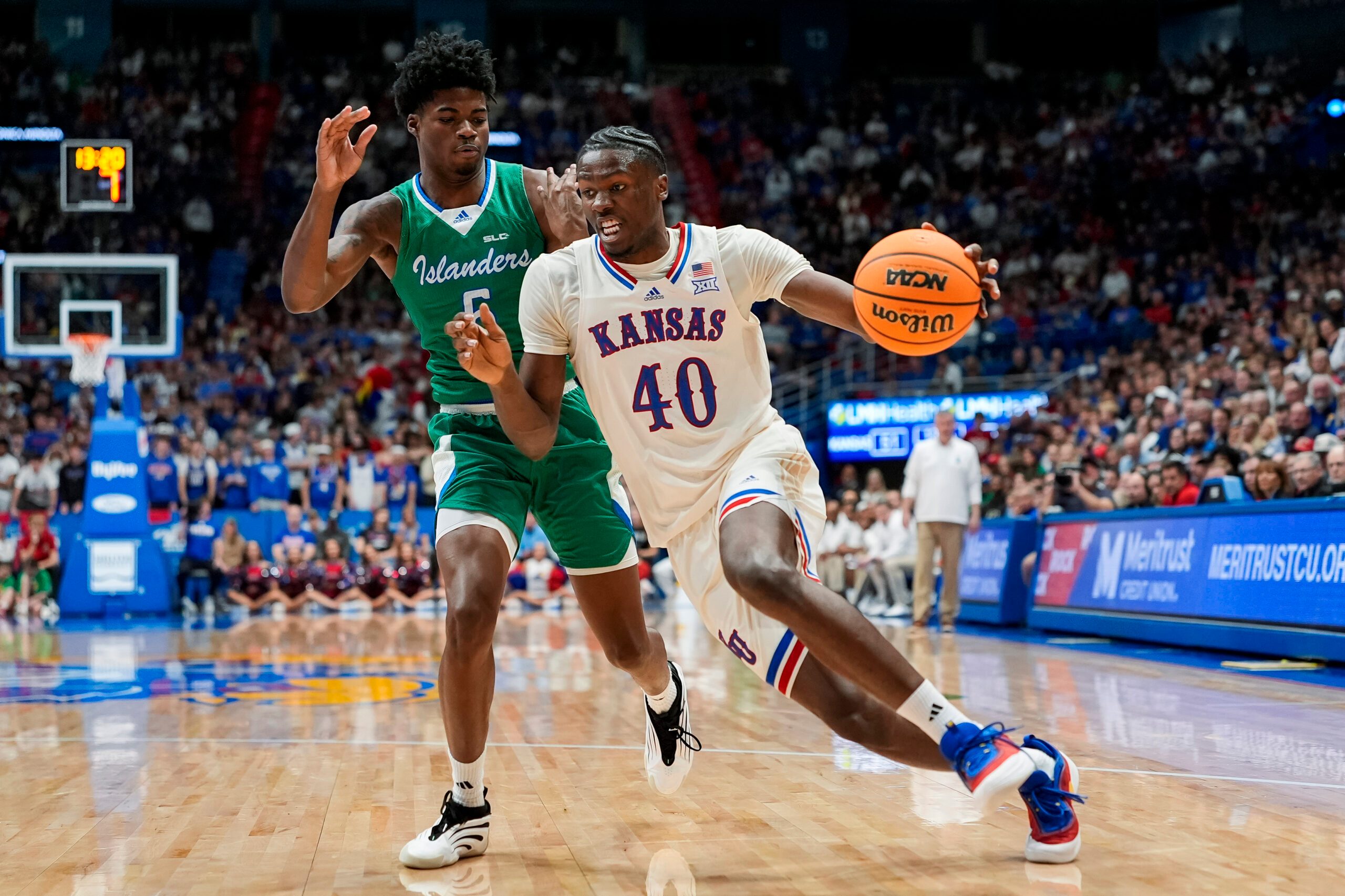 Nov 11, 2025; Lawrence, Kansas, USA; Kansas Jayhawks forward Flory Bidunga (40) drives against Texas A&M-Corpus Christi Islanders forward Kobi Pearson (5) during the second half at Allen Fieldhouse. Mandatory Credit: Jay Biggerstaff-Imagn Images