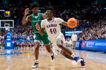 Nov 11, 2025; Lawrence, Kansas, USA; Kansas Jayhawks forward Flory Bidunga (40) drives against Texas A&M-Corpus Christi Islanders forward Kobi Pearson (5) during the second half at Allen Fieldhouse. Mandatory Credit: Jay Biggerstaff-Imagn Images