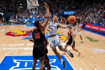 Nov 15, 2025; Lawrence, Kansas, USA; Kansas Jayhawks guard Tre White (3) shoots against Princeton Tigers forward Jacob Huggins (12) and forward Malik Abdullahi (7) during the second half at Allen Fieldhouse. Mandatory Credit: Jay Biggerstaff-Imagn Images