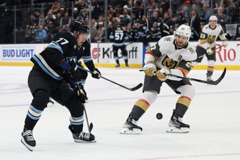 Nov 20, 2025; Salt Lake City, Utah, USA; Utah Mammoth right wing JJ Peterka (77) and Vegas Golden Knights defenseman Shea Theodore (27) battle for the puck during the first period at Delta Center. Mandatory Credit: Rob Gray-Imagn Images