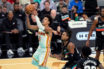 Nov 20, 2025; San Antonio, Texas, USA; Atlanta Hawks forward Jalen Johnson (1) drives to the basket past San Antonio Spurs guard Devin Vassell (24) during the second half at Frost Bank Center. Mandatory Credit: Scott Wachter-Imagn Images