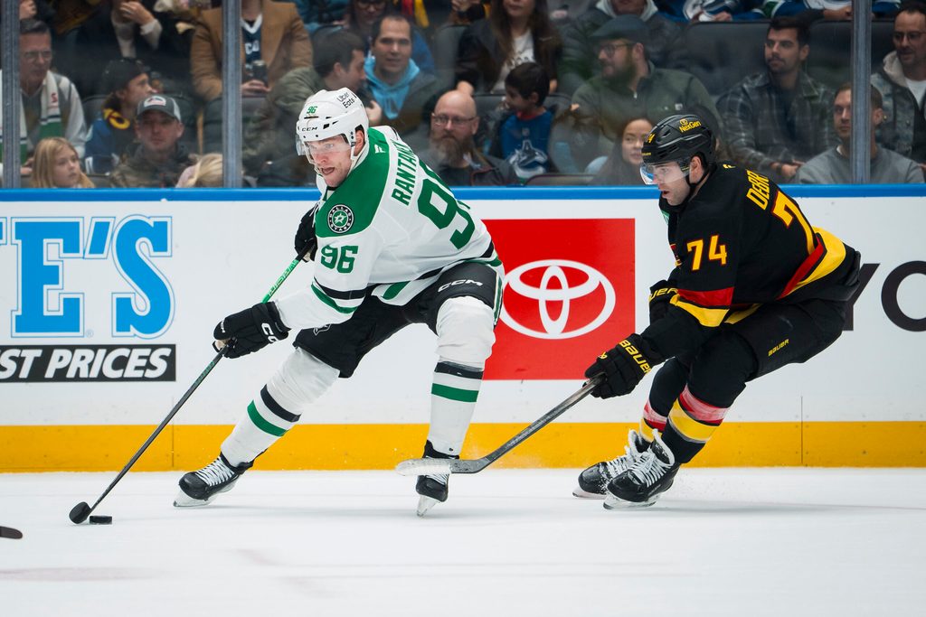 Nov 20, 2025; Vancouver, British Columbia, CAN; Dallas Stars forward Mikko Rantanen (96) drives past Vancouver Canucks forward Jake DeBrusk (74) in the first period at Rogers Arena. Mandatory Credit: Bob Frid-Imagn Images