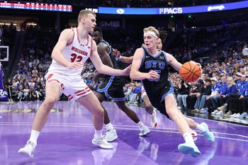Nov 21, 2025; Salt Lake City, Utah, USA; BYU Cougars guard Richie Saunders (15) drives against Wisconsin Badgers forward Aleksas Bieliauskas (32) during the second half at Delta Center. Mandatory Credit: Rob Gray-Imagn Images
