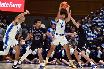 Nov 21, 2025; Durham, North Carolina, USA; Duke Blue Devils forward Cameron Boozer (12) looks to pass as Niagara Purple Eagles forward Will Shortt (32) defends during the first half at Cameron Indoor Stadium. Mandatory Credit: Rob Kinnan-Imagn Images