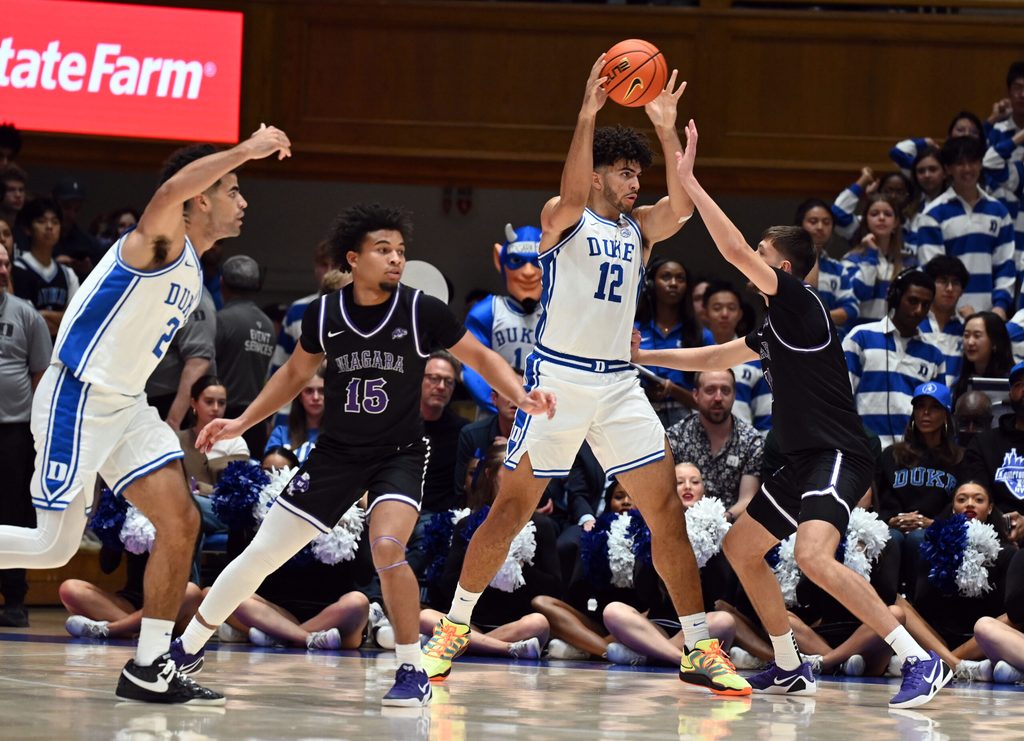 Nov 21, 2025; Durham, North Carolina, USA; Duke Blue Devils forward Cameron Boozer (12) looks to pass as Niagara Purple Eagles forward Will Shortt (32) defends during the first half at Cameron Indoor Stadium. Mandatory Credit: Rob Kinnan-Imagn Images