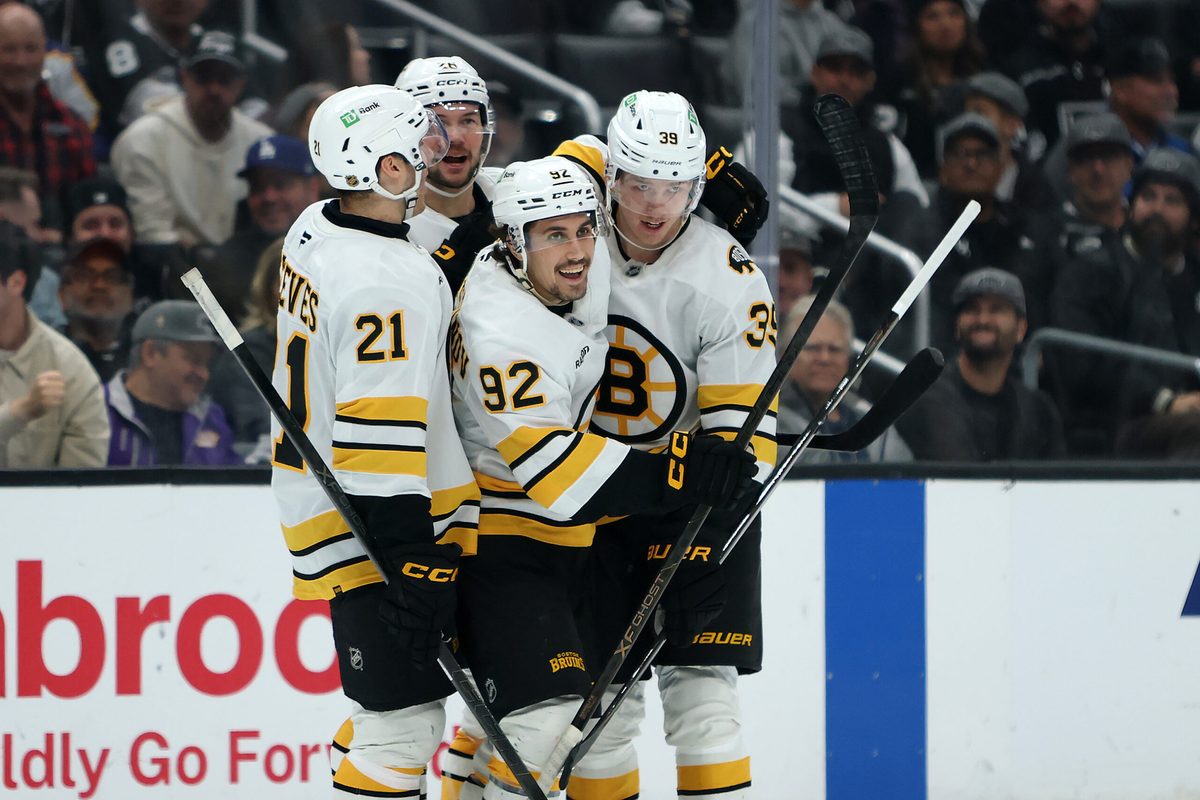 Nov 21, 2025; Los Angeles, California, USA; Boston Bruins center Morgan Geekie (39) celebrates with center Alex Steeves (21) and center Marat Khusnutdinov (92) and defenseman Andrew Peeke (26) after scoring a goal during the third period against the Los Angeles Kings at Crypto.com Arena. Mandatory Credit: Kiyoshi Mio-Imagn Images