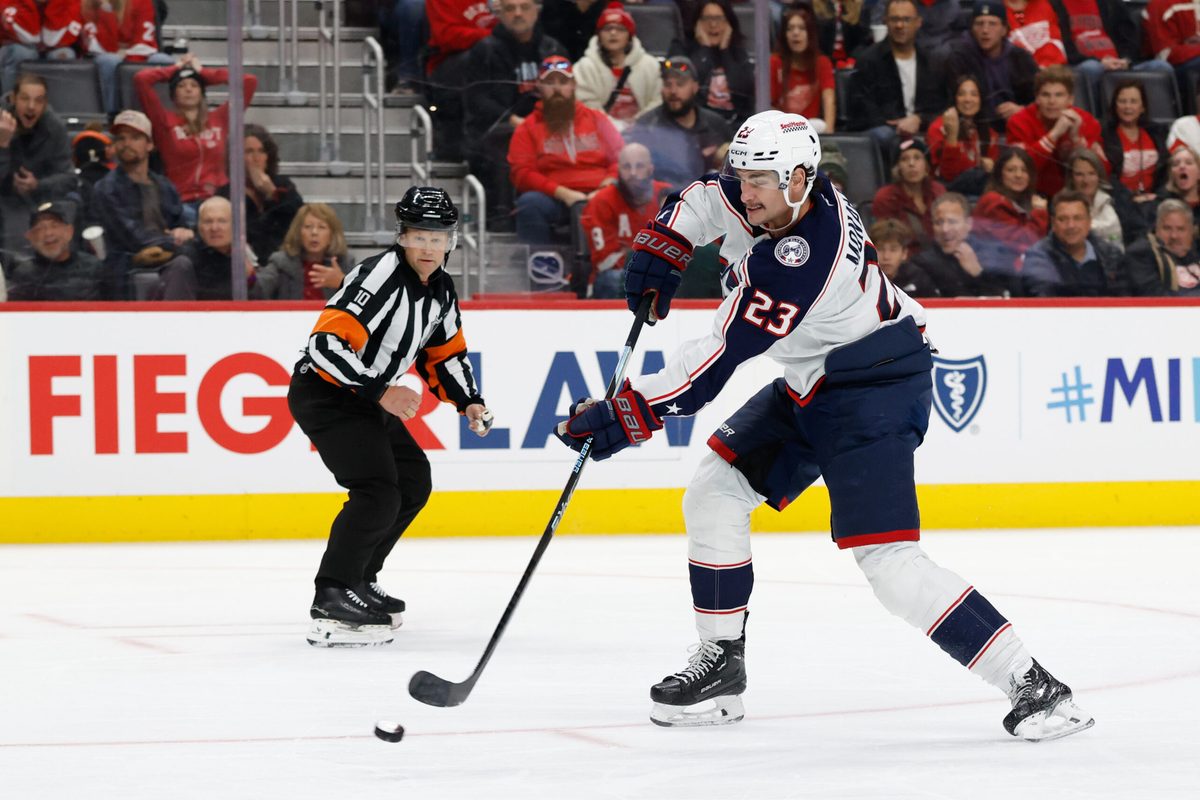 Nov 22, 2025; Detroit, Michigan, USA; Columbus Blue Jackets center Sean Monahan (23) takes a shot in the third period against the Detroit Red Wings at Little Caesars Arena. Mandatory Credit: Rick Osentoski-Imagn Images
