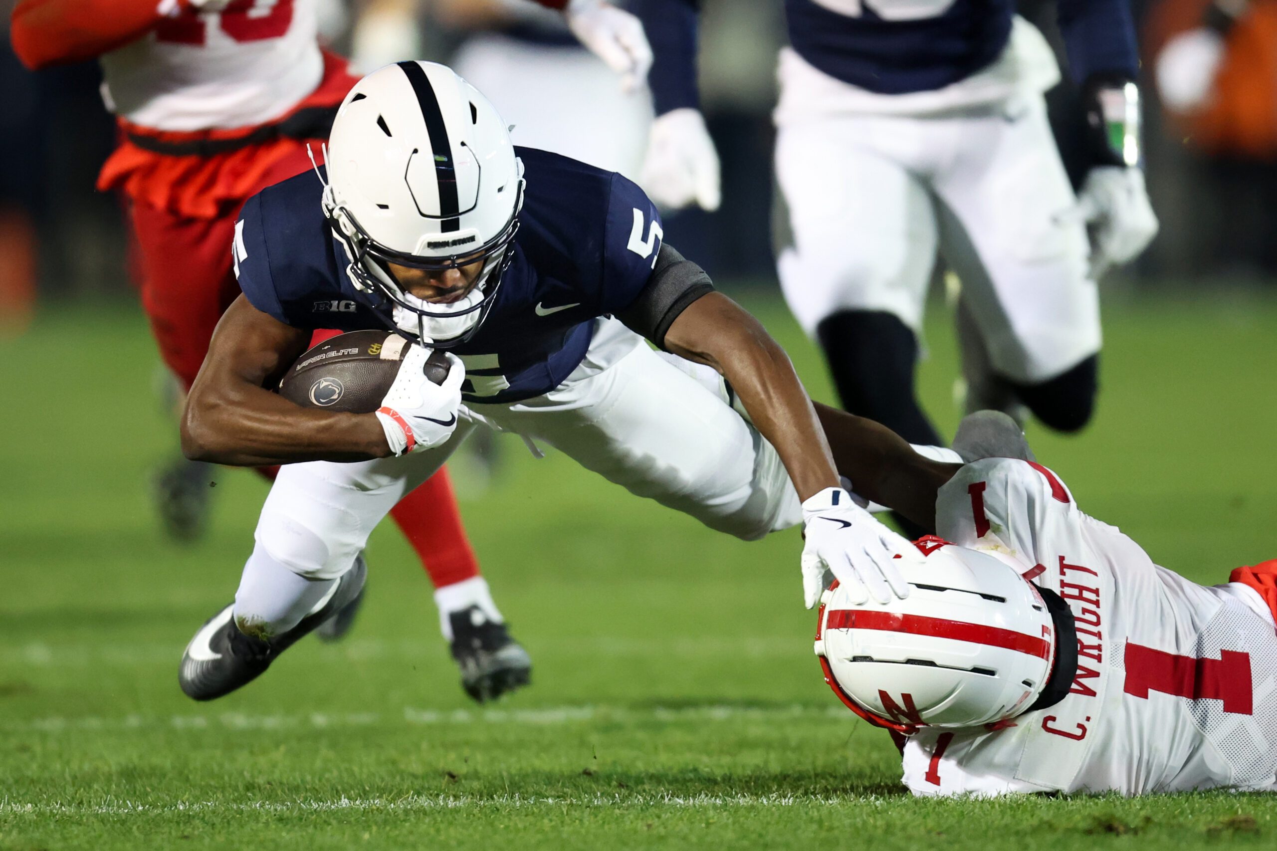 Nov 22, 2025; University Park, Pennsylvania, USA; Penn State Nittany Lions wide receiver Devonte Ross (5) runs with the ball before being tackled by Nebraska Cornhuskers defensive back Ceyair Wright (1) during the second quarter at Beaver Stadium. Mandatory Credit: Matthew O'Haren-Imagn Images