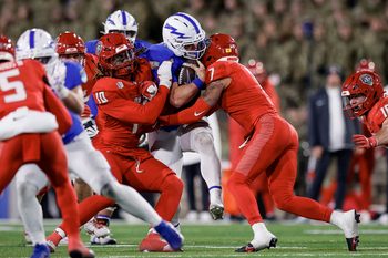 Nov 22, 2025; Colorado Springs, Colorado, USA; Air Force Falcons quarterback Kemper Hodges (4) is sacked by New Mexico Lobos defensive end Darren Agu (10) and safety Tavian Combs (7) in the third quarter at Falcon Stadium. Mandatory Credit: Isaiah J. Downing-Imagn Images