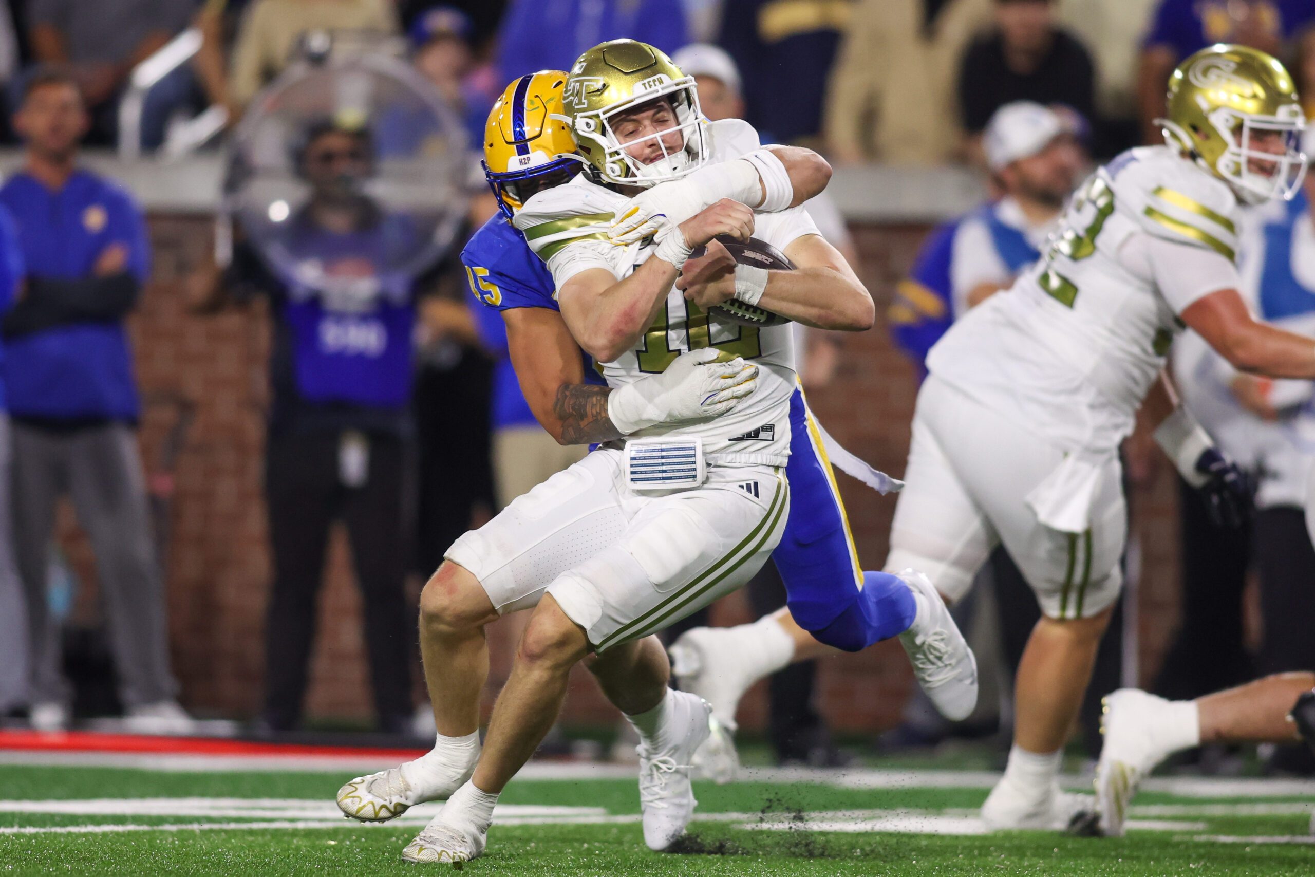 Nov 22, 2025; Atlanta, Georgia, USA; Georgia Tech Yellow Jackets quarterback Haynes King (10) is tackled by Pittsburgh Panthers defensive lineman Joey Zelinsky (45) in the third quarter at Bobby Dodd Stadium at Hyundai Field. Mandatory Credit: Brett Davis-Imagn Images