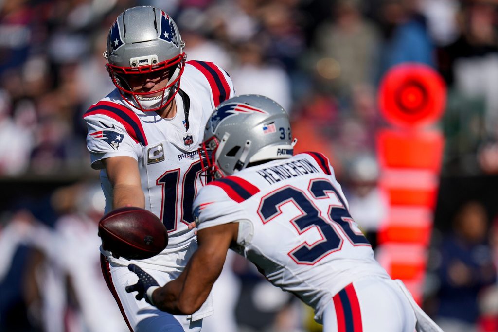 Nov 23, 2025; Cincinnati, Ohio, USA; New England Patriots quarterback Drake Maye (10) hands off to running back TreVeyon Henderson (32) in the first quarter at Paycor Stadium. Mandatory Credit: Sam Greene-USA TODAY Network via Imagn Images