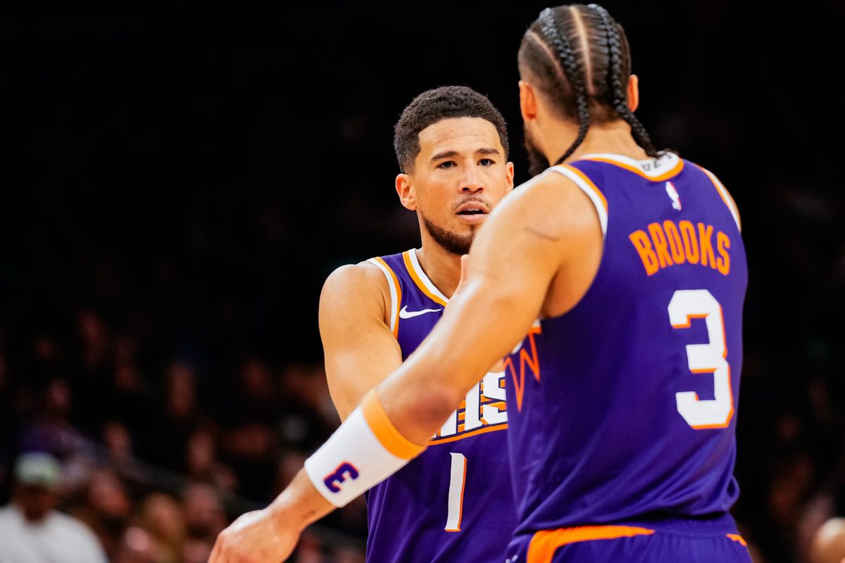 Nov 23, 2025; Phoenix, Arizona, USA; Phoenix Suns guard Devin Booker (1) and Dillon Brooks (3) high five in the second half of the game at Mortgage Match Up Center. Mandatory Credit: Arianna Grainey-Imagn Images