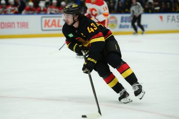 Nov 23, 2025; Vancouver, British Columbia, CAN;  Vancouver Canucks defenseman Quinn Hughes (43) skates with the puck during the third period against the Calgary Flames at Rogers Arena. Mandatory Credit: Simon Fearn-Imagn Images