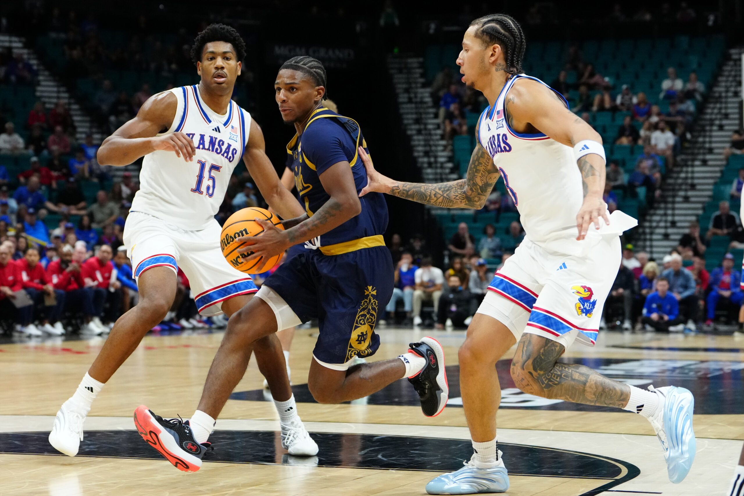 Nov 24, 2025; Las Vegas, Nevada, USA; Notre Dame Fighting Irish guard Markus Burton (3) drives the lane on Kansas Jayhawks forward Bryson Tiller (15) during the second half in a 2025 Players Era Festival group play game at MGM Grand Garden Arena. Mandatory Credit: Stephen R. Sylvanie-Imagn Images