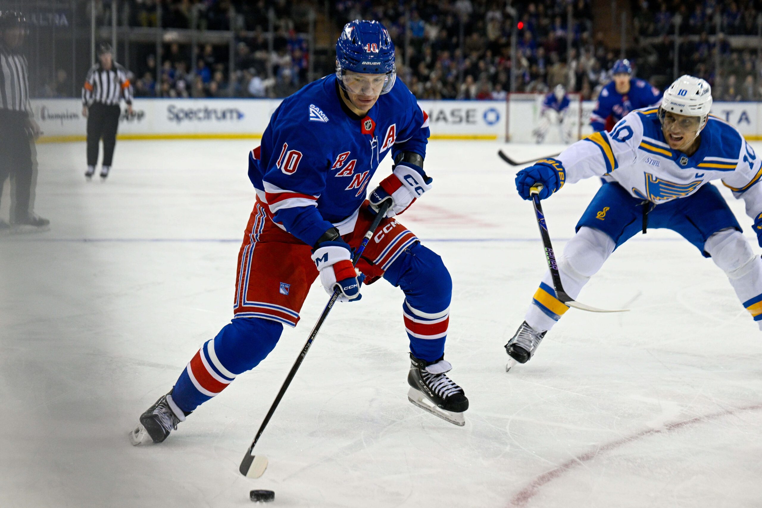 Nov 24, 2025; New York, New York, USA; New York Rangers left wing Artemi Panarin (10) plays the puck defended by St. Louis Blues center Brayden Schenn (10) during the second period at Madison Square Garden. Mandatory Credit: Dennis Schneidler-Imagn Images
