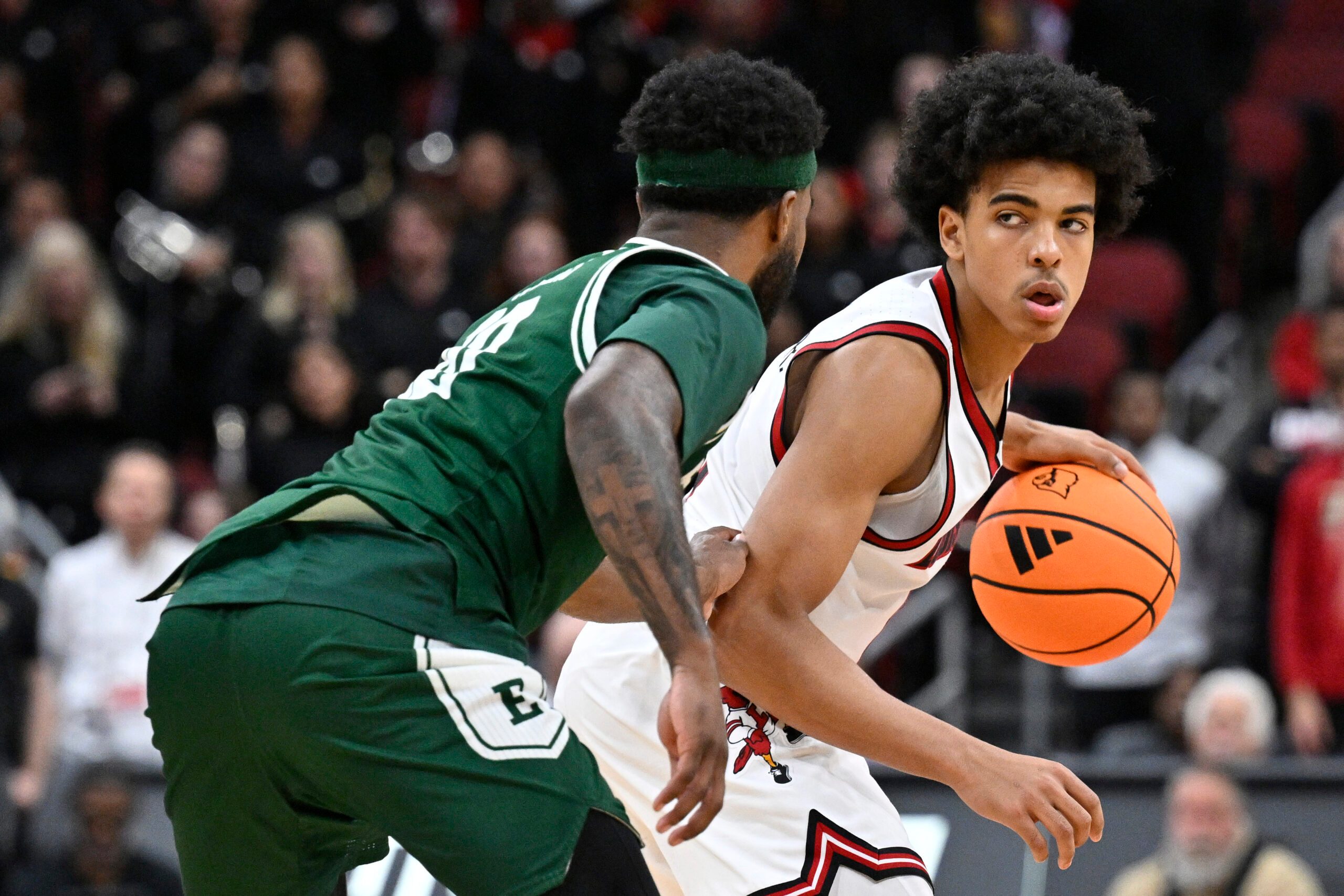 Nov 24, 2025; Louisville, Kentucky, USA;  Louisville Cardinals guard Mikel Brown Jr. (0) dribbles against Eastern Michigan Eagles guard Jon Sanders (10) during the second half at KFC Yum! Center. Louisville defeated Eastern Michigan 87-46. Mandatory Credit: Jamie Rhodes-Imagn Images