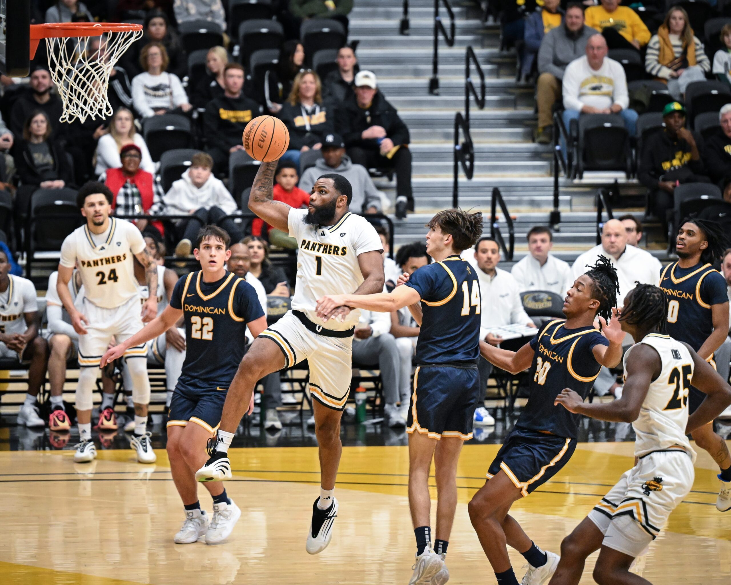 UW-Milwaukee guard Amar Augillard (1) goes to the basket past Dominican forward Frank Paszkowski (22) and Dominican guard/forward Dominic Crapia (14) in a game Tuesday, November 25, 2025, at the Klotsche Center in Milwaukee, Wisconsin.