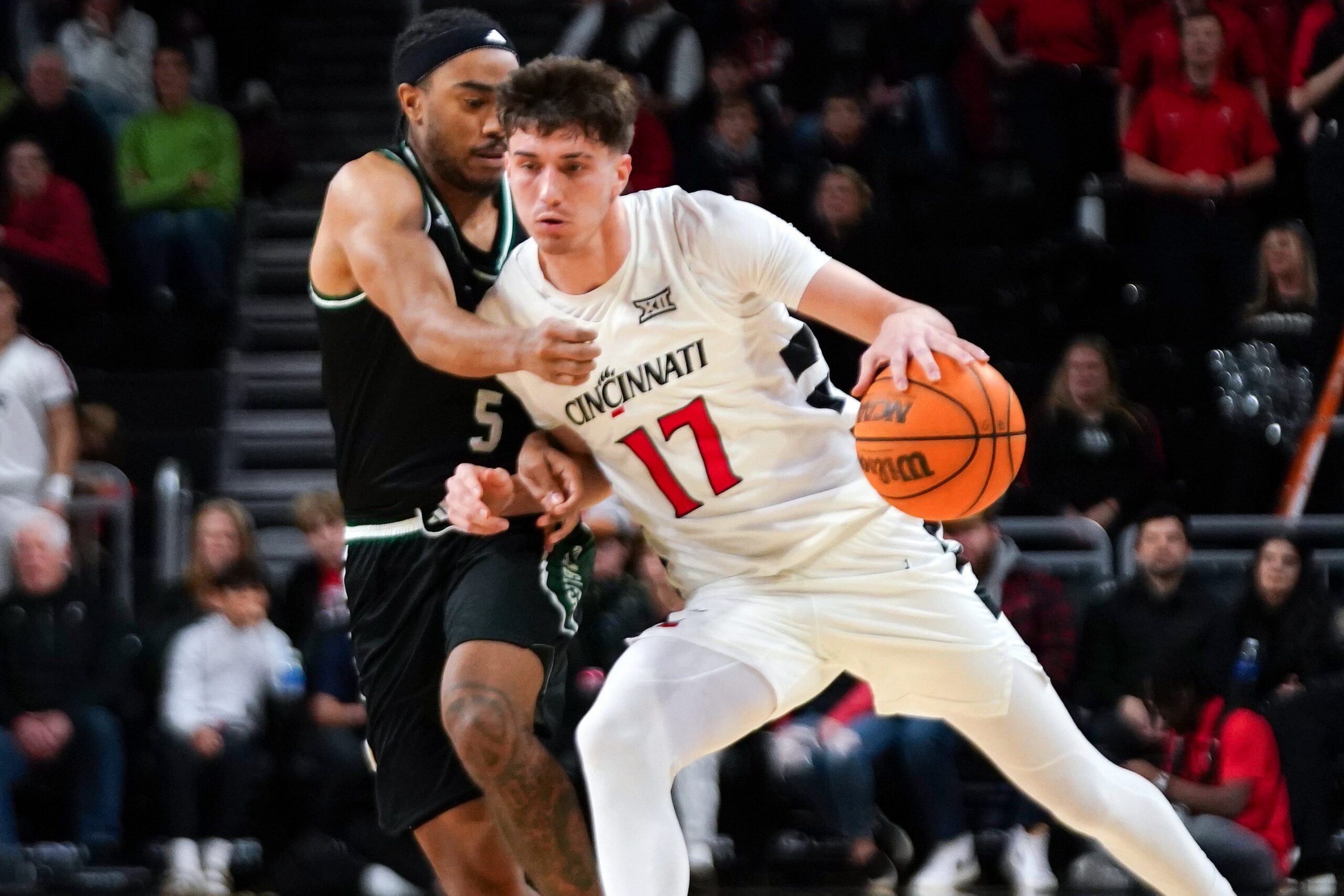 Cincinnati Bearcats guard Jordi Rodriguez (17) drives the ball past Eastern Michigan Eagles guard Braelon Green (5) in the second half of a NCAA men’s basketball game between the Cincinnati Bearcats and Eastern Michigan Eagles, Wednesday, Nov. 26, 2025, at Fifth Third Arena in Cincinnati. Eagles won 64-56.