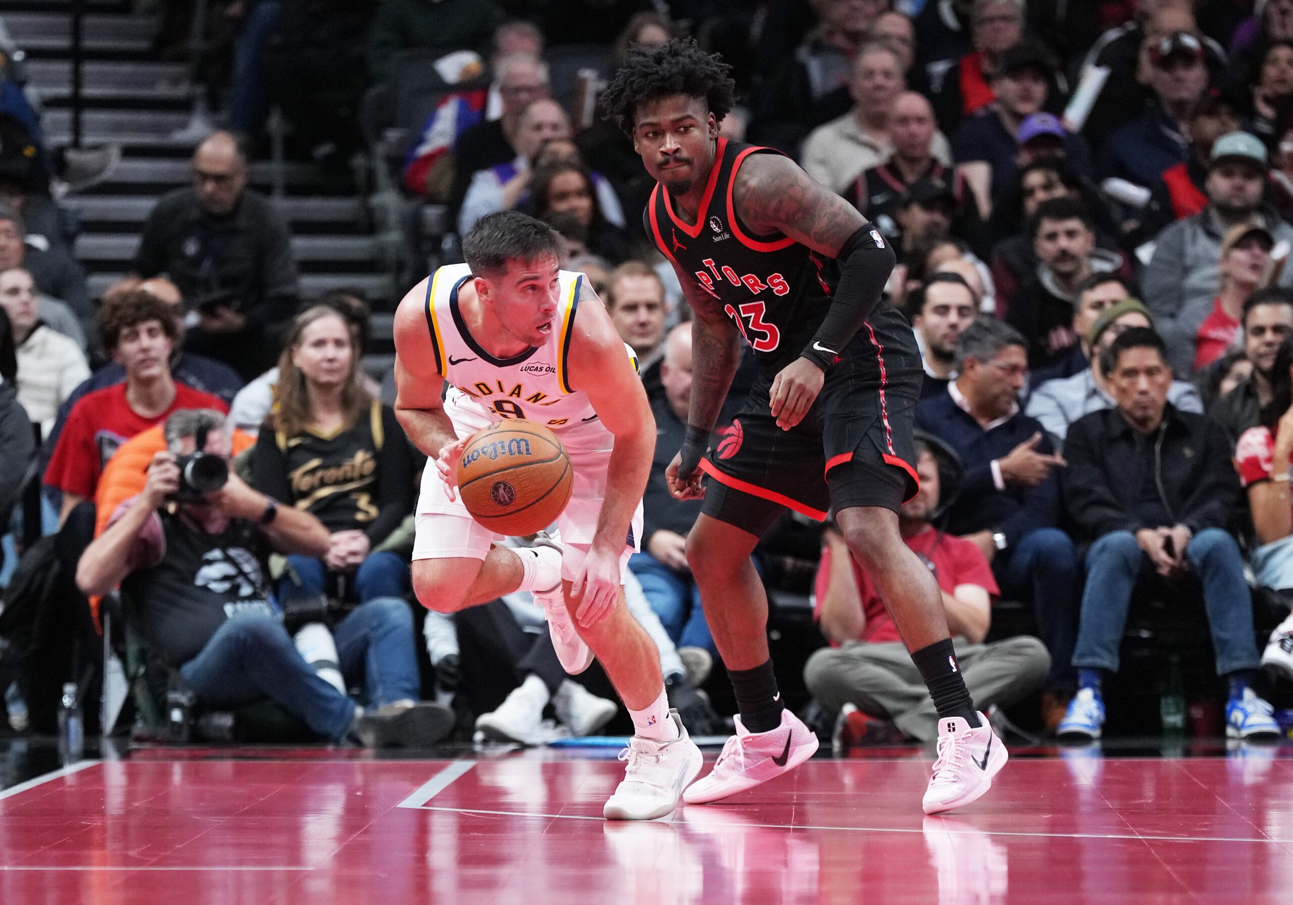Nov 26, 2025; Toronto, Ontario, CAN; Indiana Pacers guard T.J. McConnell (9) controls the ball as Toronto Raptors guard Jamal Shead (23) tries to defend during the fourth quarter at Scotiabank Arena. Mandatory Credit: Nick Turchiaro-Imagn Images