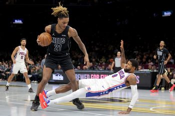 Nov 28, 2025; Brooklyn, New York, USA; Brooklyn Nets forward Noah Clowney (21) controls the ball against Philadelphia 76ers forward Paul George (8) during the third quarter at Barclays Center. Mandatory Credit: Brad Penner-Imagn Images