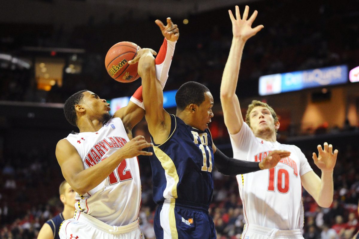 Dec 14, 2011; College Park, MD, USA; FIU Panthers guard Phil Taylor (11) throws a behind the back pass to forward Gilles Dierickx (back) as Maryland Terrapins guard Terrell Stoglin (12) and forward Berend Weijs (10) defend in the second half at Comcast Center. Maryland defeated FIU 65-61.  Mandatory Credit: James Lang-Imagn Images
