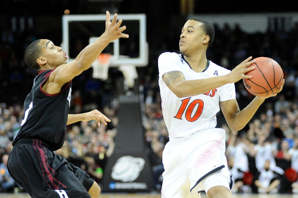 Mar 20, 2014; Spokane, WA, USA; Cincinnati Bearcats guard Troy Caupain (10) is defended by Harvard Crimson guard Siyani Chambers (1, left) in the first half of a men's college basketball game during the second round of the 2014 NCAA Tournament at Veterans Memorial Arena. Mandatory Credit: James Snook-Imagn Images