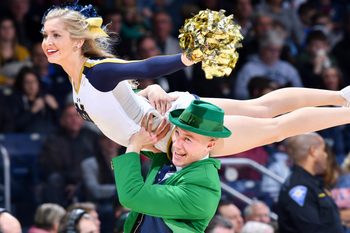 Jan 12, 2019; South Bend, IN, USA; The Notre Dame Leprechaun carries a cheerleader during a time out in the second half of the game between the Notre Dame Fighting Irish and the Boston College Eagles at the Purcell Pavilion. Mandatory Credit: Matt Cashore-Imagn Images