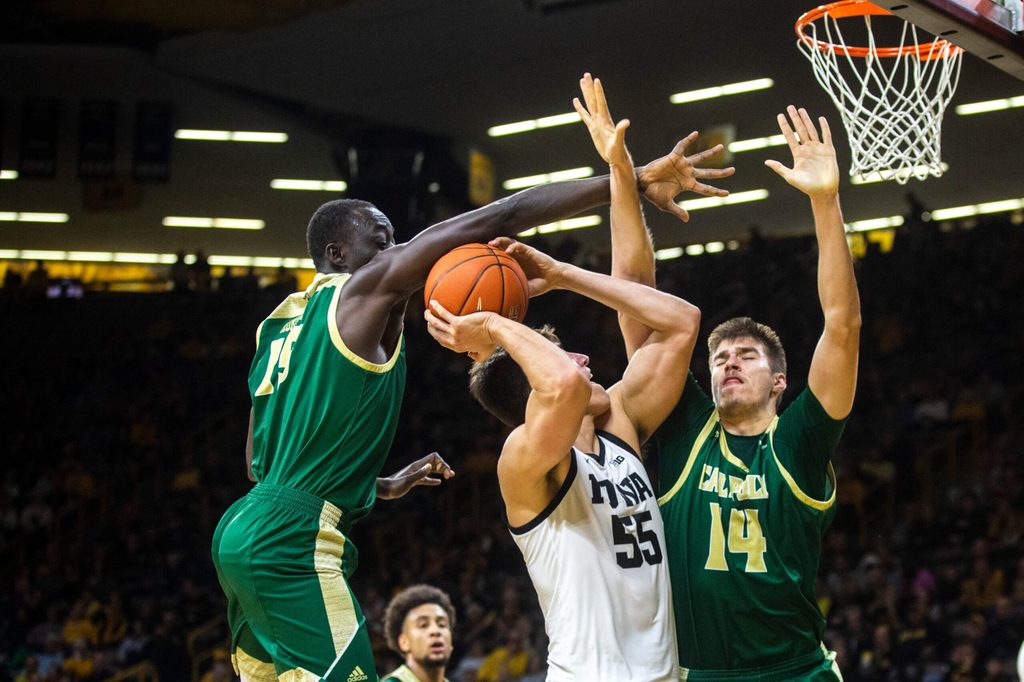 Iowa center Luka Garza (55) gets fouled by Cal Poly's Alimamy Koroma, left, as Tuukka Jaakkola (14) defends during a NCAA non-conference men's basketball game, Sunday, Nov. 24, 2019, at Carver-Hawkeye Arena in Iowa City, Iowa.
191123 Cal Poly Iowa Mbb 028 Jpg