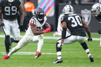 Oct 23, 2022; Paradise, Nevada, USA; Houston Texans running back Dare Ogunbowale (33) rushes towards Las Vegas Raiders safety Duron Harmon (30) during the second half at Allegiant Stadium. Mandatory Credit: Stephen R. Sylvanie-Imagn Images