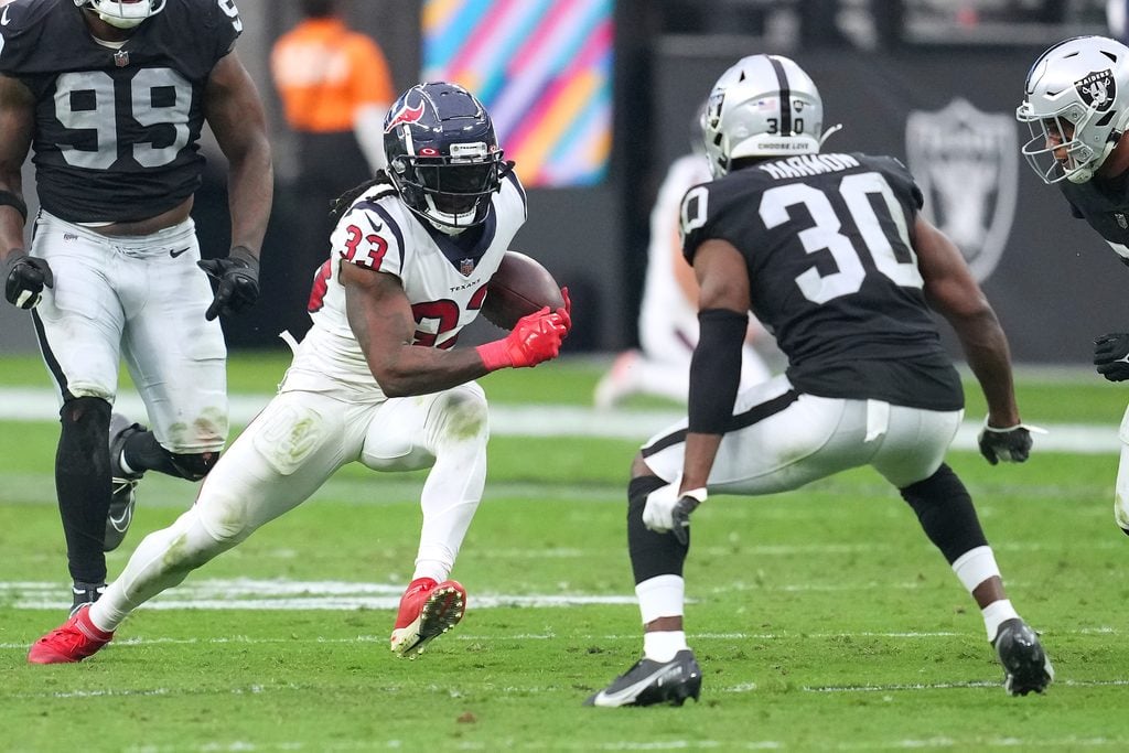 Oct 23, 2022; Paradise, Nevada, USA; Houston Texans running back Dare Ogunbowale (33) rushes towards Las Vegas Raiders safety Duron Harmon (30) during the second half at Allegiant Stadium. Mandatory Credit: Stephen R. Sylvanie-Imagn Images