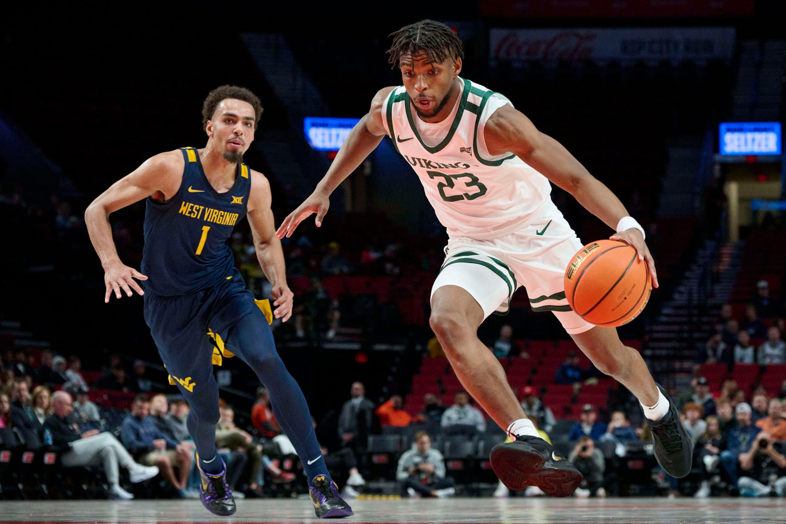 Nov 25, 2022; Portland, Oregon, USA; Portland State Vikings guard Jorell Saterfield (23) drives to the basket past West Virginia Mountaineers forward Emmitt Matthews Jr. (1) during the first half at Moda Center. Mandatory Credit: Troy Wayrynen-Imagn Images