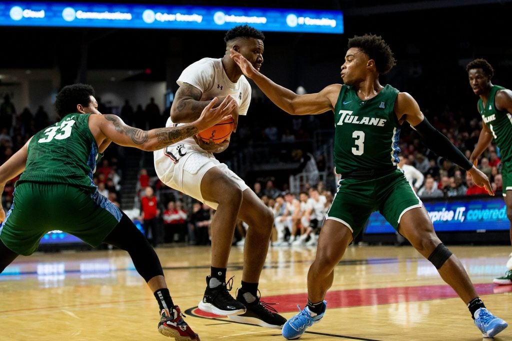 Cincinnati Bearcats guard Landers Nolley II (2) defends the ball against Tulane Green Wave forward Tylan Pope (33) and Tulane Green Wave guard Jalen Cook (3) during the first half of an NCAA men s college basketball game on Thursday, Dec. 29, 2022, at Fifth Third Arena in Cincinnati. The Bearcats defeated the Green Wave 88-77 with a crowd of 9,484.
Tulane Green Wave At Cincinnati Bearcats Ncaa Basketball Dec 29