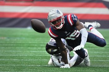 New England receiver Nelson Agholor , being brought down by Raven defender Kyle Hamilton, watches as his fumbled ball bounces away after a 28yard, 4th quarter run.   The ball was recovered by the Ravens and ended Patriots chances of a comeback win.   [The Providence Journal / Kris Craig]
