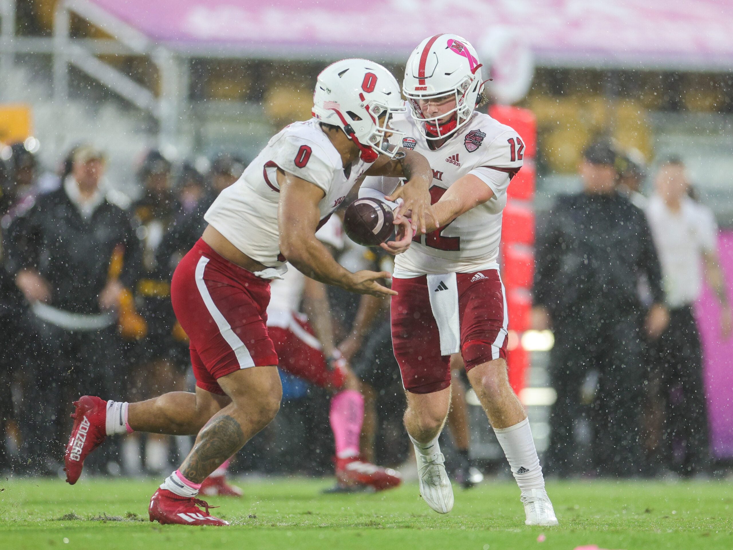 Dec 16, 2023; Orlando, FL, USA;  Miami (OH) Redhawks quarterback Henry Hesson (12) hands off to running back Rashad Amos (0) against the Appalachian State Mountaineers in the first quarter during the Avocados from Mexico Cure Bowl at FBC Mortgage Stadium. Mandatory Credit: Nathan Ray Seebeck-Imagn Images