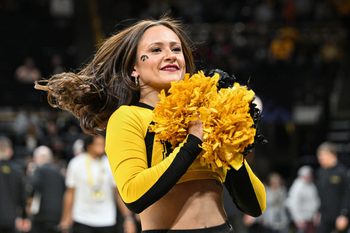Dec 29, 2023; Iowa City, Iowa, USA; A Iowa Hawkeyes cheerleader looks on during the game against the Northern Illinois Huskies at Carver-Hawkeye Arena. Mandatory Credit: Jeffrey Becker-Imagn Images