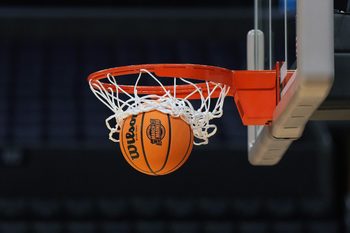 Mar 27, 2024; Los Angeles, CA, USA; A Wilson official Evo NXT game basketball with March Madness and Elite 8 and Sweet logo approaches the rim and net at Crypto.com Arena. Mandatory Credit: Kirby Lee-Imagn Images