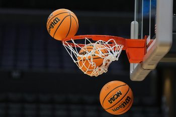 Mar 27, 2024; Los Angeles, CA, USA; Wilson official Evo NXT game basketballs with March Madness and Elite 8 and Sweet logo approaches the rim and net at Crypto.com Arena. Mandatory Credit: Kirby Lee-Imagn Images