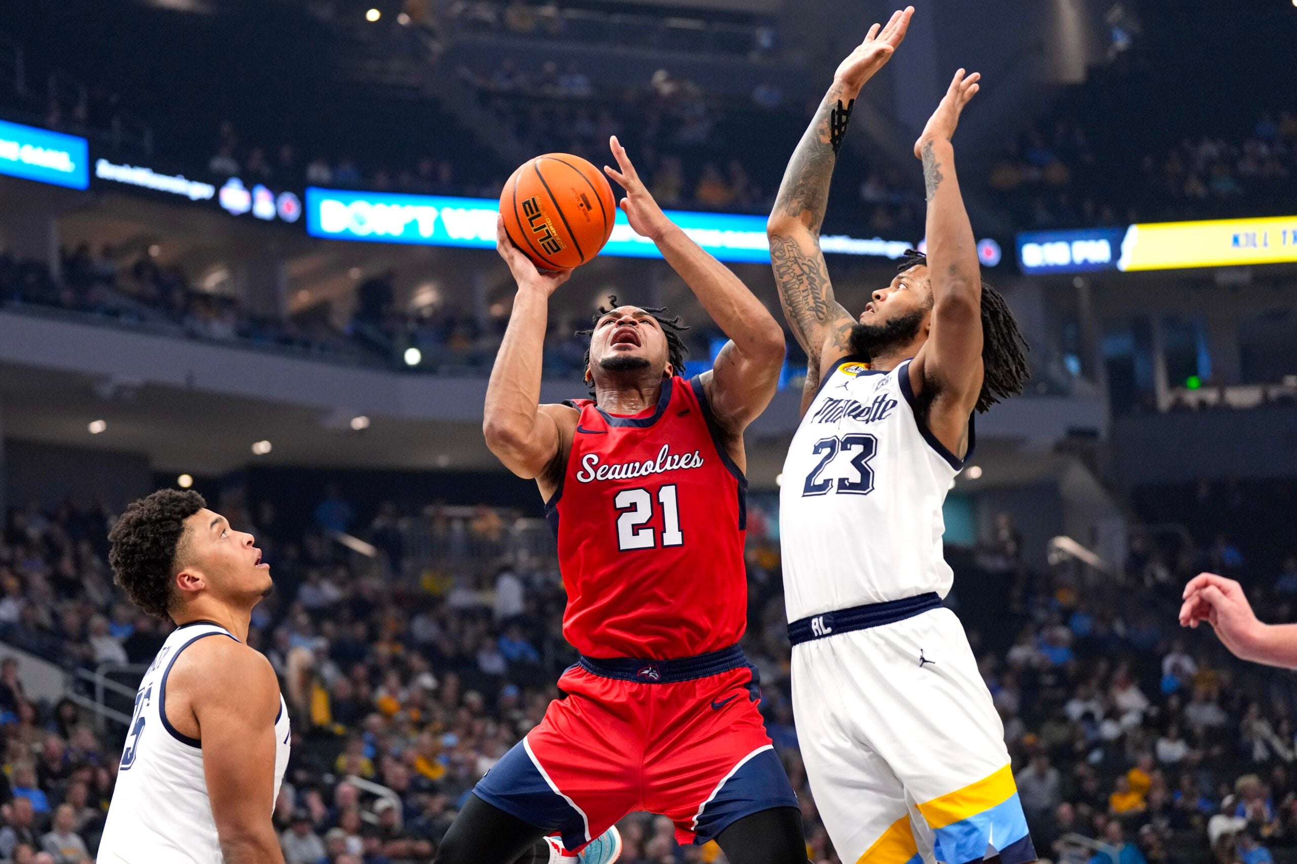 Nov 4, 2024; Milwaukee, Wisconsin, USA;  Stony Brook Seawolves guard-forward Andre Snoddy (21) shoots around Marquette Golden Eagles forward David Joplin (23) during the first half at Fiserv Forum. Mandatory Credit: Jeff Hanisch-Imagn Images