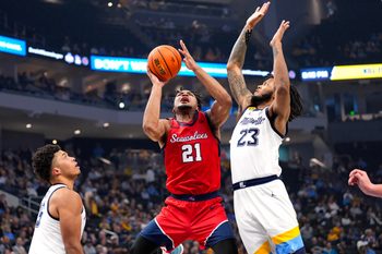 Nov 4, 2024; Milwaukee, Wisconsin, USA;  Stony Brook Seawolves guard-forward Andre Snoddy (21) shoots around Marquette Golden Eagles forward David Joplin (23) during the first half at Fiserv Forum. Mandatory Credit: Jeff Hanisch-Imagn Images